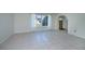 Bright living room with neutral tile, large windows providing natural light, and an arched entryway to the hall at 23051 Elmira Blvd, Punta Gorda, FL 33980