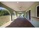 Covered patio with ceiling fan, arched openings, and sliding glass doors at 23051 Elmira Blvd, Punta Gorda, FL 33980