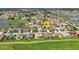 Aerial view of property highlighting location within the community with mature landscaping, golf course and water views at 24055 Buckingham Way, Punta Gorda, FL 33980