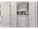 Bright laundry room boasts an updated washer and dryer, upper cabinets and functional shelving for storage solutions at 24055 Buckingham Way, Punta Gorda, FL 33980