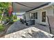 Inviting paved patio with retractable awning, outdoor seating, and views of the landscaped backyard at 24055 Buckingham Way, Punta Gorda, FL 33980