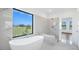 Spa-like bathroom with freestanding tub, walk-in shower, and scenic outdoor views at 24166 Colima Ct, Punta Gorda, FL 33955