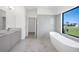 Elegant bathroom featuring a soaking tub, dual vanity, and marble-style tile at 24166 Colima Ct, Punta Gorda, FL 33955