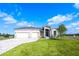 Inviting single-Gathering home featuring a three-car garage, modern design, and manicured lawn at 24166 Colima Ct, Punta Gorda, FL 33955