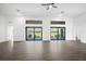 Well-lit living room with tile flooring, ceiling fan, and views of the landscaped backyard at 24166 Colima Ct, Punta Gorda, FL 33955