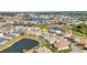 Aerial view of home overlooking a scenic pond and a golf course, and surrounded by lush landscaping at 24371 Westgate Blvd, Port Charlotte, FL 33980