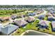 A high-angle shot of a neighborhood with a lush green golf course, pond, and well-maintained homes at 24371 Westgate Blvd, Port Charlotte, FL 33980