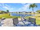 Back patio with comfortable outdoor seating, overlooking a serene lake and well-maintained landscaping at 24371 Westgate Blvd, Port Charlotte, FL 33980
