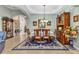 Formal dining room with wainscoting, chandelier, and large area rug, adjacent to other living spaces at 24371 Westgate Blvd, Port Charlotte, FL 33980