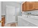 Functional laundry room with Amana washer and dryer and storage cabinets above appliances at 24371 Westgate Blvd, Port Charlotte, FL 33980