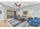 Open-concept living room offering tile floors, modern ceiling fan, comfortable seating, and screened patio access at 24371 Westgate Blvd, Port Charlotte, FL 33980