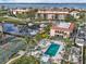 Aerial view of a community featuring a pool, tennis court, boats, and beautiful landscaping at 25188 Marion Ave # 1013, Punta Gorda, FL 33950
