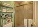 Bathroom featuring decorative glass sliding shower door and adjacent shelving for towel and accessory storage at 25188 Marion Ave # 1013, Punta Gorda, FL 33950