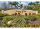 Well-maintained entrance to Emerald Pointe with manicured landscaping and vibrant flowers at 25188 Marion Ave # 1013, Punta Gorda, FL 33950