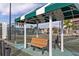 View of the community tennis court with sheltered bench seating at 25188 Marion Ave # 1013, Punta Gorda, FL 33950