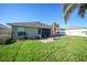 Green backyard featuring a brick patio with outdoor seating and a grill for entertaining at 27002 Clear Creek Way, Punta Gorda, FL 33950