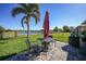 Outdoor seating area on a brick patio, perfect for enjoying the lush green lawn and lake view at 27002 Clear Creek Way, Punta Gorda, FL 33950