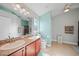 Bright bathroom featuring dual sinks, wooden cabinets, and light fixtures at 27002 Clear Creek Way, Punta Gorda, FL 33950