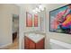 Powder room with cherry cabinets and decorative art on wall at 27002 Clear Creek Way, Punta Gorda, FL 33950