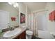 Bright bathroom with a granite-topped vanity and a tub-shower combination, complemented by decorative art at 27002 Clear Creek Way, Punta Gorda, FL 33950