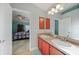 Bathroom featuring dual sinks, wooden cabinets and view into the Primary bedroom at 27002 Clear Creek Way, Punta Gorda, FL 33950