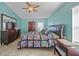 Well-lit bedroom with tile floors, ceiling fan, colorful quilt, and dark wood furniture at 27002 Clear Creek Way, Punta Gorda, FL 33950