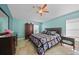 Cozy bedroom featuring colorful quilt bedding, a ceiling fan, and blue walls at 27002 Clear Creek Way, Punta Gorda, FL 33950