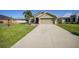 Well-kept home boasting a spacious driveway, verdant lawn, and tropical palm trees for curb appeal at 27002 Clear Creek Way, Punta Gorda, FL 33950