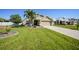Inviting single-story home showcasing manicured lawn, mature palms, and a well-maintained landscape at 27002 Clear Creek Way, Punta Gorda, FL 33950