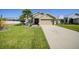 Charming home featuring well-maintained lawn, mature palm trees, and a spacious driveway at 27002 Clear Creek Way, Punta Gorda, FL 33950