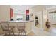 Bright eat-in kitchen with bar stool seating, modern appliances and view of the laundry room at 27002 Clear Creek Way, Punta Gorda, FL 33950