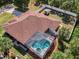 Aerial view of the home featuring a screened-in pool, spa, well-maintained roof, and landscaped backyard at 3172 Sikeston Ave, North Port, FL 34286