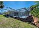 Backyard features a screened lanai with a pool and spa, along with lush landscaping at 3172 Sikeston Ave, North Port, FL 34286