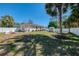 Backyard showing white fence, landscaping, and a shed, enhanced with mature palm trees and clear blue skies at 3172 Sikeston Ave, North Port, FL 34286