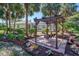 Backyard features a pergola with a swing, framed by landscaped gardens and a screened-in outdoor living area at 3172 Sikeston Ave, North Port, FL 34286