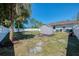 Backyard view features a storage shed, framed by a white fence and mature landscaping under a clear sky at 3172 Sikeston Ave, North Port, FL 34286