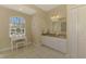 Bright bathroom boasts dual sinks, granite countertops, tiled floor, and ample natural light from the arched window at 3172 Sikeston Ave, North Port, FL 34286