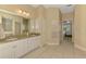 A spacious bathroom featuring a dual sink vanity with granite countertop and a view leading to the main bedroom at 3172 Sikeston Ave, North Port, FL 34286