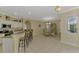 Open-concept kitchen and dining area with white cabinets, granite countertops, and breakfast bar at 3172 Sikeston Ave, North Port, FL 34286