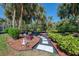 Detailed landscape design with a curved walkway and vibrant greenery set against a backdrop of mature trees at 3172 Sikeston Ave, North Port, FL 34286