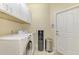 Bright laundry room features front loading washer and dryer, white cabinets and tile floors at 3172 Sikeston Ave, North Port, FL 34286