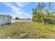 Backyard with a lush lawn, privacy fencing, and a view of a shed at 3243 Elkcam Blvd, Port Charlotte, FL 33952