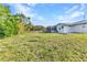 A grassy backyard features a lush lawn, privacy fence, and a screened porch at 3243 Elkcam Blvd, Port Charlotte, FL 33952
