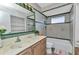 Well-lit bathroom with vanity, mirror and tiled shower at 3243 Elkcam Blvd, Port Charlotte, FL 33952