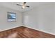 A spacious bedroom with hardwood floors, a window, and a ceiling fan at 3243 Elkcam Blvd, Port Charlotte, FL 33952
