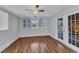 Bedroom features wood floors, shuttered window, and a glass paneled door at 3243 Elkcam Blvd, Port Charlotte, FL 33952