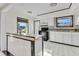 Bright kitchen with white cabinets, a marble countertop peninsula, and black appliances and window trim at 3243 Elkcam Blvd, Port Charlotte, FL 33952