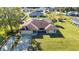 Aerial view of a house with a sprawling lawn, a long driveway, and a glimpse of the neighborhood at 3880 Pinstar Ter, North Port, FL 34287