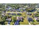 Aerial shot of a residential area featuring lush greenery, well-maintained homes, and a serene lake in the distance at 3880 Pinstar Ter, North Port, FL 34287
