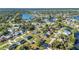 Aerial view of a suburban neighborhood with mature trees, well-maintained lawns and water views at 3880 Pinstar Ter, North Port, FL 34287